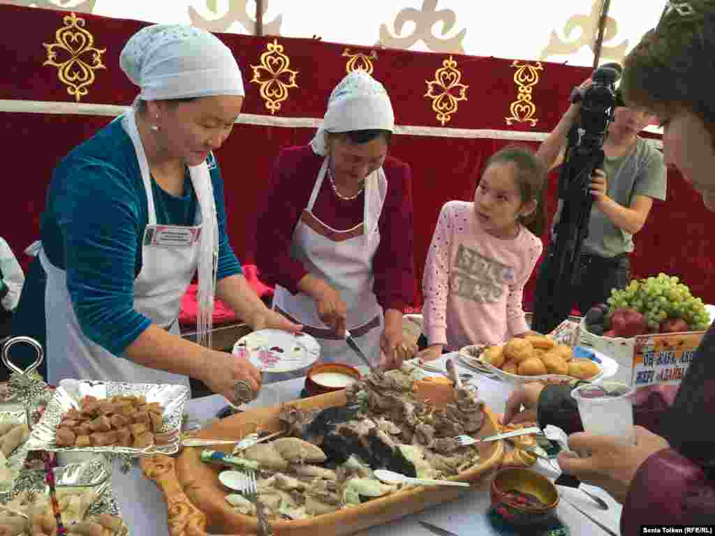 Бейнеу ауданынан келген Алмагүл Есбергенова (сол жақта) шұбатқа қоса қазақтың дәстүрлі тағамы - асылған етті ала келіпті.